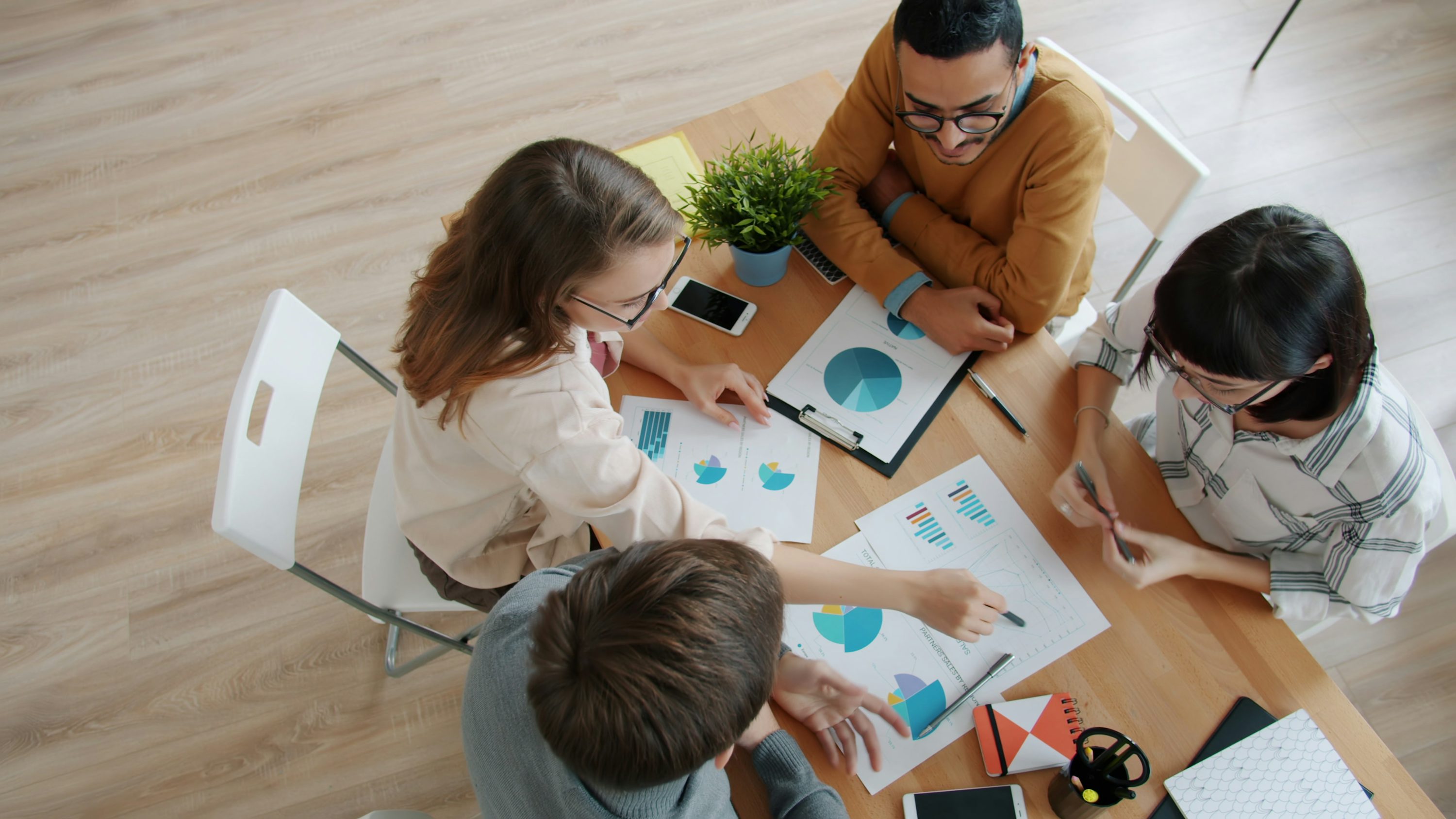 Pessoas analisando informações financeiras em uma mesa de trabalho